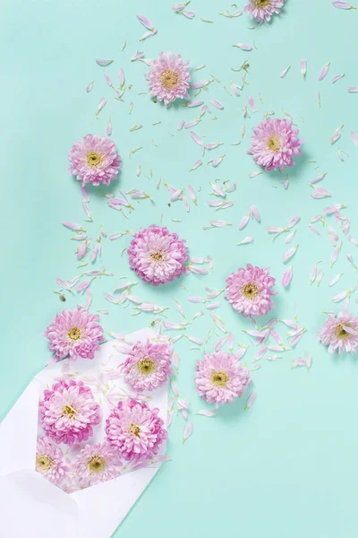 Umschlag Mit Blumen Und Blütenblättern Auf Pastellfarbenem Hintergrund — Stockfoto