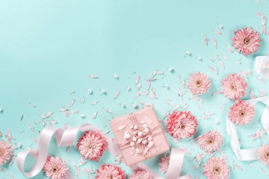 Çiçek ve hediye kutusu pastel bir arka plan üzerinde çiçekler kompozisyonu