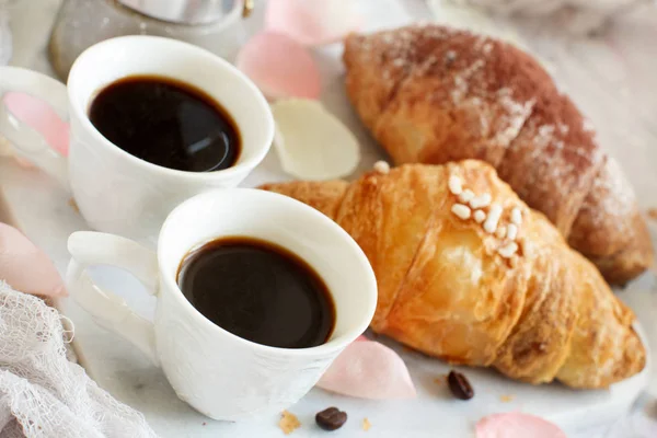 Breakfast with coffee and croissant close up with coffee beans