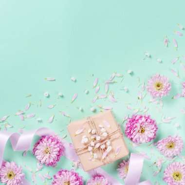 Pastel bir arka plan üzerinde kalpleri ve hediye kutusu ile çiçek kompozisyon