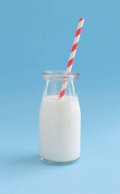 Süt bir kavanoz ve şişe mavi bir arka plan üzerinde Kapat