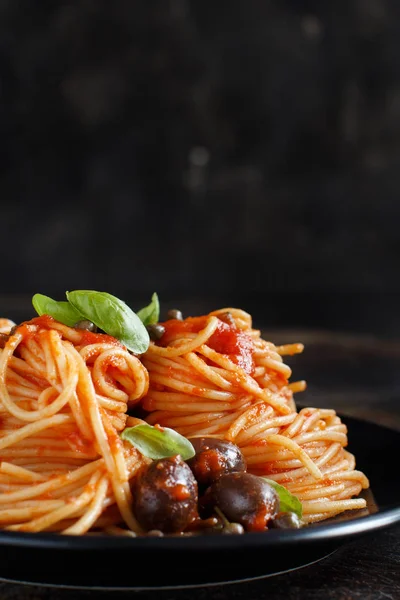 Espaguetis con salsa de tomate aceitunas y alcaparras —  Fotos de Stock