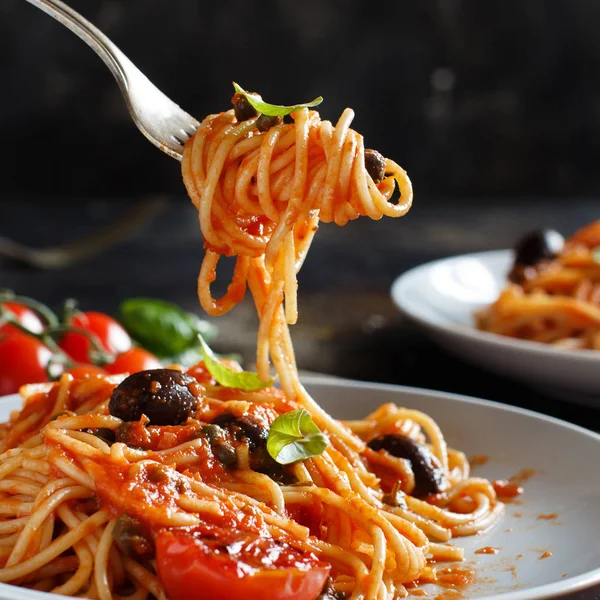 Espaguete com azeitonas e alcaparras de molho de tomate — Fotografia de Stock
