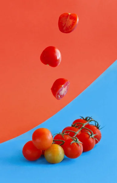 Вишневі помідори на синьому і кораловому червоному тлі — стокове фото