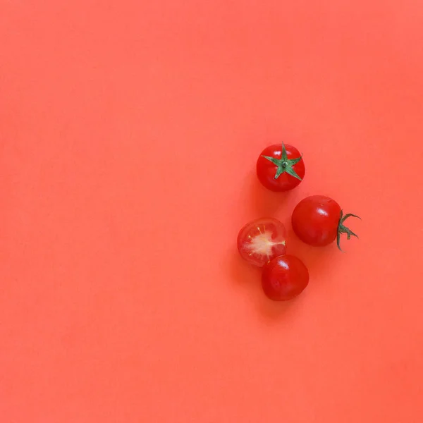 Tomates cereja em um fundo vermelho de coral — Fotografia de Stock