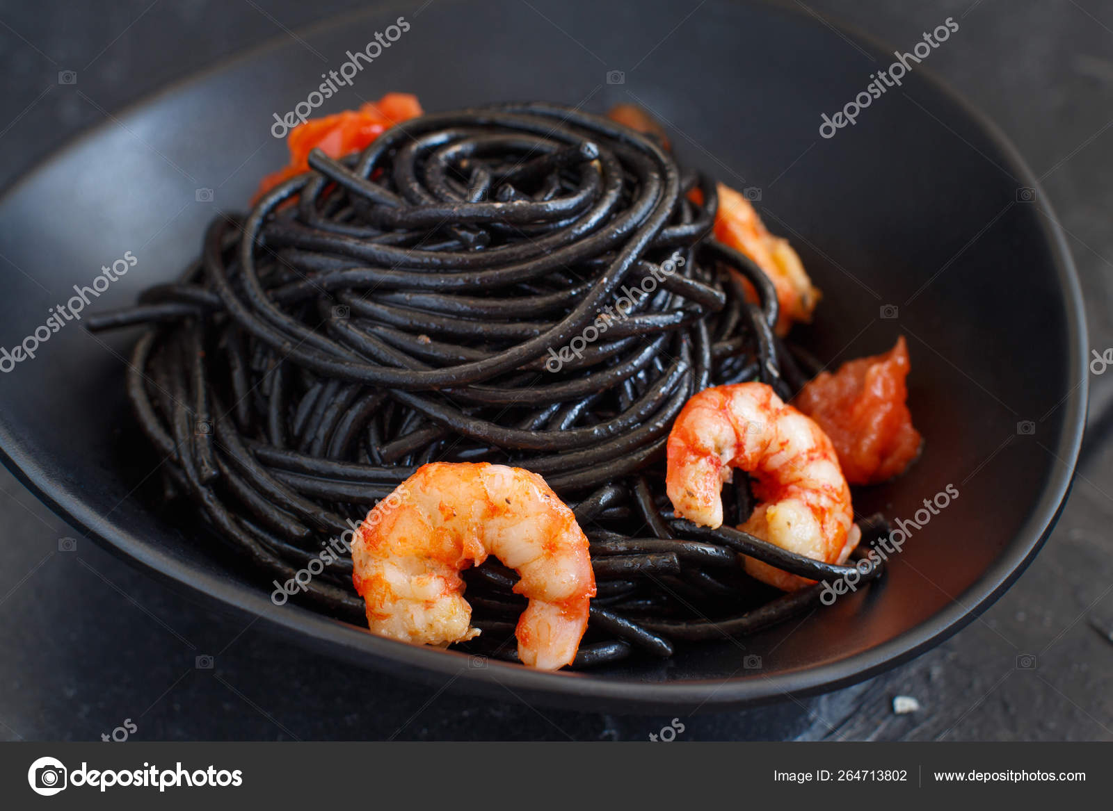 Squid ink pasta with prawns and tomatoes Stock Photo by ©karissaa 264713802