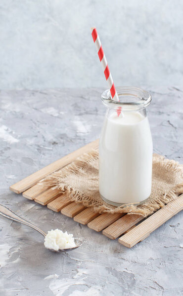 Fermented drink kefir in small bottle and kefir grains
