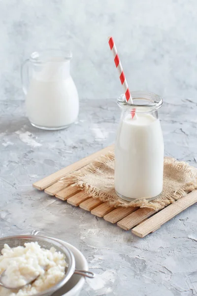 Kéfir de bebida fermentada en botellas pequeñas y granos de kéfir — Foto de Stock