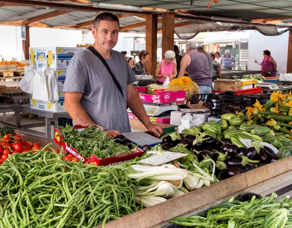 Vendedor de verduras en un mercado de agricultores locales — Foto de Stock