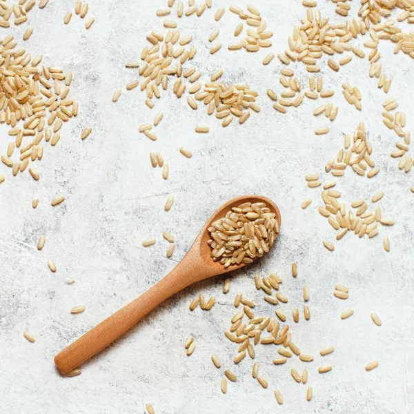 Brunt ris i en träskål med sked — Stockfoto