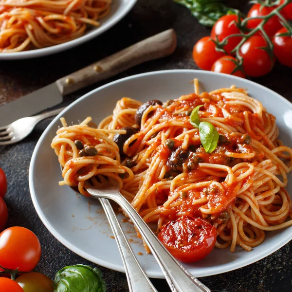 Espaguetis con salsa de tomate aceitunas y alcaparras —  Fotos de Stock