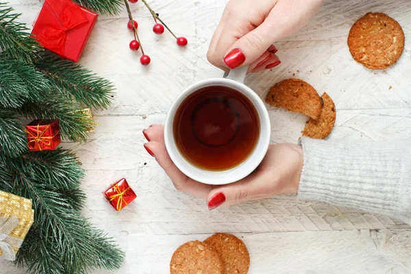 Christmas composition with hands keeping tea mug