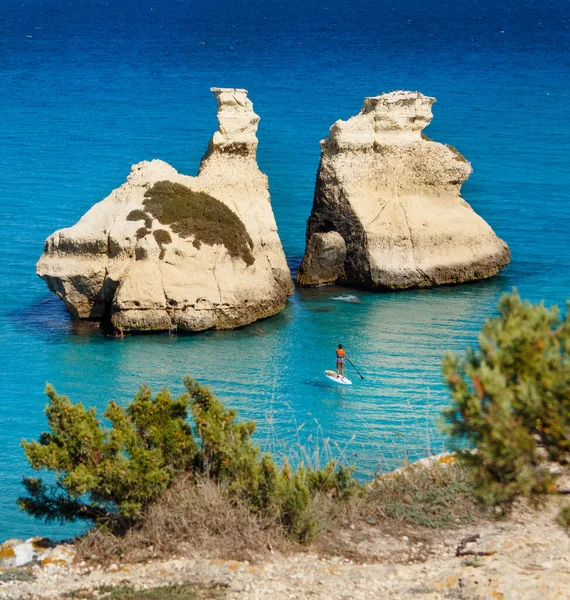 The Two Sisters stacks in front of the shore of Torre dell\'Orso