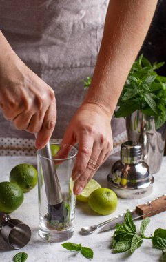 Eller barmen aletlerini kullanarak Mojito kokteyli yapıyor.