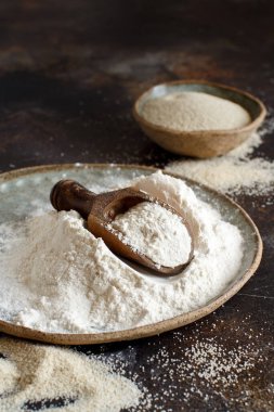 Çiğ fonio unu ve koyu arka planda kaşıkla tohumlar. Alternatif un