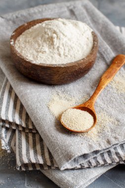 Bir kase çiğ fonio unu ve bir kaşık dolusu tohum peçeteye yakın. Alternatif un