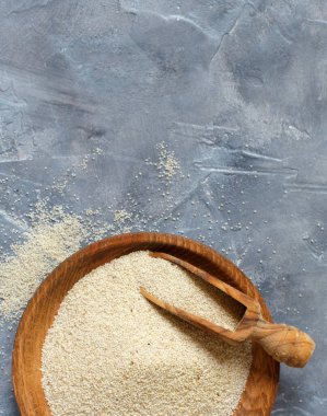 Çiğ pişmemiş fonio tohumları ve gri arka plan görünümlü bir kaşık fotokopi alanı