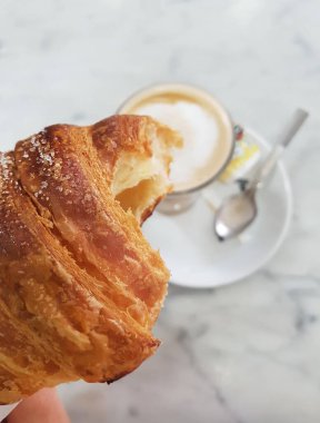 Barın üst katında kruvasan ve kahve yemek.