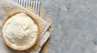 Çiğ beyaz kinoa döşeme ve tohumlar gri bir masanın üstünde.