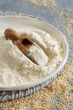 Gri bir masada beyaz kinoa unu ve tohum. Yakın plan.