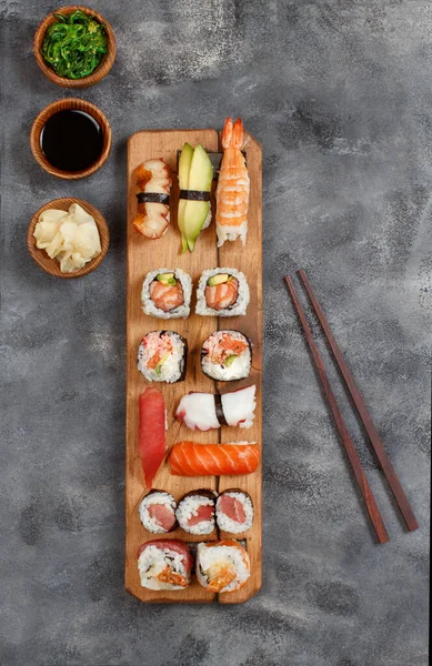 Sushi设置黑鬼和寿司滚动在木制托盘顶部视图 — 图库照片