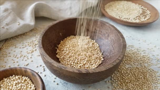 Verser le quinoa blanc cru dans un bol en bois fermer — Video
