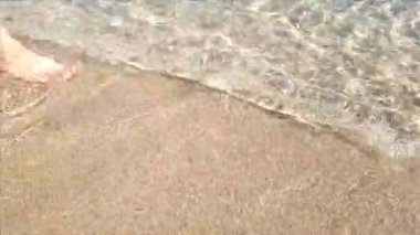 Kapalı kadın bacakları Denizde sahil boyunca yürür