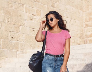 Merdivenlerden inip güneş gözlüklerine dokunan genç kadınlar.