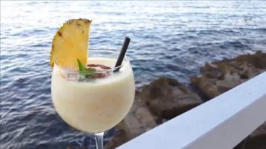 Gün batımında deniz kenarında Pina colada kokteyli