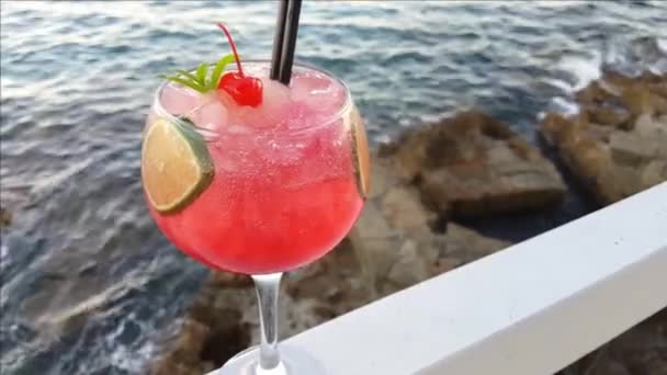 Pink kosmopolitan koktail dekat laut pada saat matahari terbenam — Stok Video