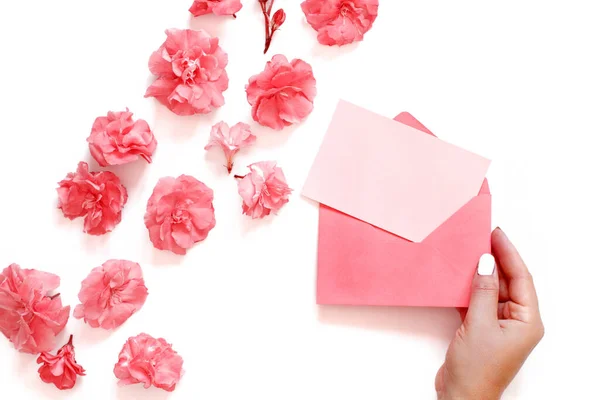 用手把粉红的信封贴在粉红的花朵上 放在白色的背景色上 — 图库照片