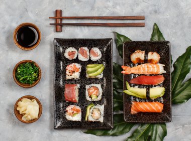 Suşi, nigiri ve suşi rulolarını dikdörtgen tabakların üstüne koy.