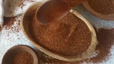 Tahta bir kasede çiğ teff tahılı. Yaklaş.