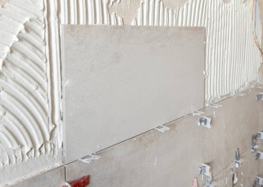 Yapışkan ve yakın çekim ile hazırlanmış bir banyo duvarı döşeme işlemi. İnşaat süreci ya da bir evin yenilenmesi, DIY ev imalatçıları