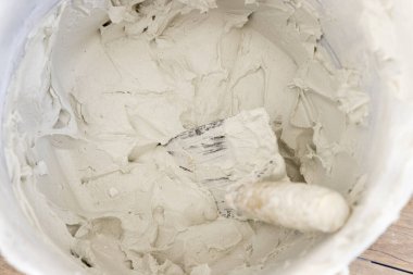 Kirli yüzeyi sıva ya da sıva kaplı, içinde mala olan, çimento kalıntılarıyla kaplı, üst manzara. İnşaat veya yenileme süreci