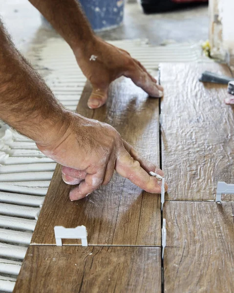 Son sınıflar seramik fayansları yapıştırıcı ile hazırlanmış bir evin zeminine yerleştiriyorlar. Bir binanın inşaatında ya da yenilenmesinde çalışan bir zanaatçı, DIY ev imalatçıları