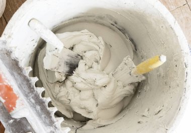 Kirli yüzeyi sıva ya da sıva kaplı, içinde mala olan, çimento kalıntılarıyla kaplı, üst manzara. İnşaat veya yenileme süreci, DIY ev geliştirme