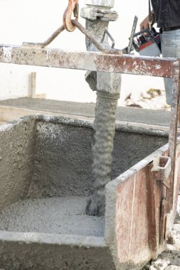 İnşaat sırasında mikserden el arabasına taze hazır beton dökülüyor. Endüstri için beton. Hammadde, endüstriyel süreç ve inşaat sahneleri temaları için mükemmel