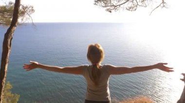 Kadın fitness oyundaki en iyi mutlu ve kutluyor başarı. kadın dağ denizden görünümünü sahiptir, ellerini yukarı yükseltir ve özgürlük ve nefes rüzgar hisseder. 4k, ağır çekim