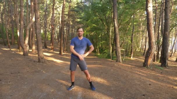 L'homme danse dans la forêt ensoleillée d'été. motivation pour l'activité sportive en plein air, l'entraînement et l'exercice dans une belle nature. éblouissement solaire, ralenti 4k, coup de steadicam — Video