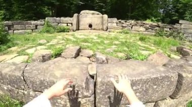 Bir turist bir eylem kamera ile Dolmen inceliyor. Dolmen ormanın içinde. turistler antik Dolmen keşfetmek