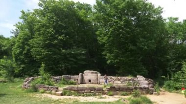 Dolmen ormanın içinde. 4k, ağır çekim. turistler antik Dolmen keşfetmek