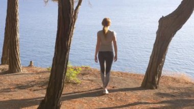 Kadın fitness oyundaki en iyi mutlu ve kutluyor başarı. kadın dağ denizden görünümünü sahiptir, özgürlük ve rüzgar nefes hissettiğini. 4 k, ağır çekim, güneş ışığı, stedikam