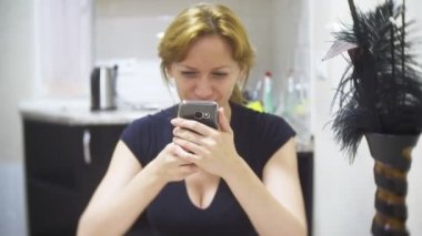kadın mutfakta evde pizza yiyor ve onun smartphone, 4 k, kullanarak arka plan bulanıklık