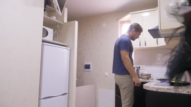 El joven abre el refrigerador. Le molesta que el refrigerador esté vacío. 4k — Vídeo de stock