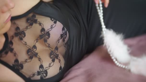 Modische Dame im Abendkleid mit schwarzer Spitze. junge Frau posiert in sinnlicher Pose mit rosafarbenen, flauschigen Handschellen in einem Raum mit exquisitem Interieur. 4k — Stockvideo