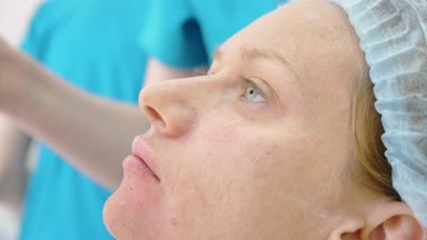 Hijyenik şapkalı bir kadın hasta yordamı doktor ofisinde bekliyor. yakın çekim. 4k