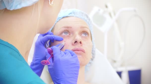 의사가 미용사 여성 환자 얼굴에 주사를 합니다. 아름다움과 화장품의 개념입니다. 4 k. — 비디오