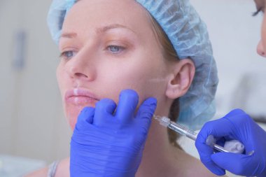 Doktor Şevval özçelik güzellik bayan hasta karşısında enjeksiyonları yapar. Güzellik ve kozmetik kavramı. 4k.
