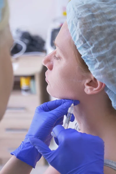 De arts schoonheidsspecialiste maakt injecties in het gezicht van de vrouwelijke patiënt. concept van schoonheid en cosmetologie. 4k. — Stockfoto